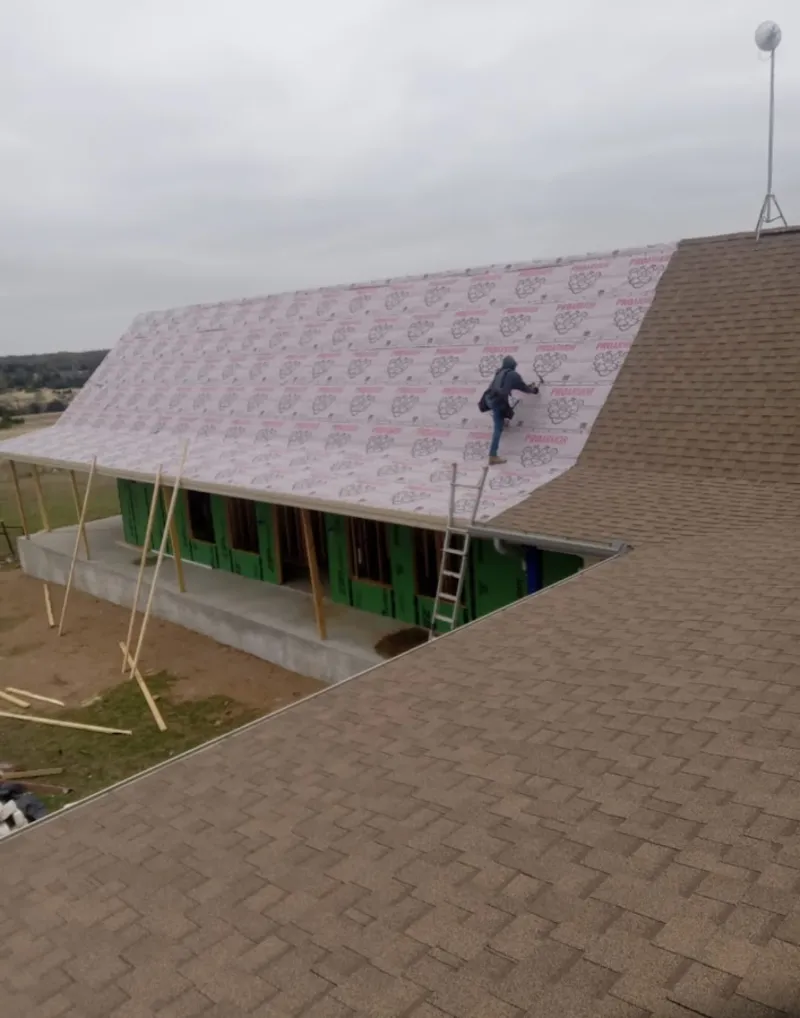 Worker preparing underlayment for a metal roof installation in Dublin